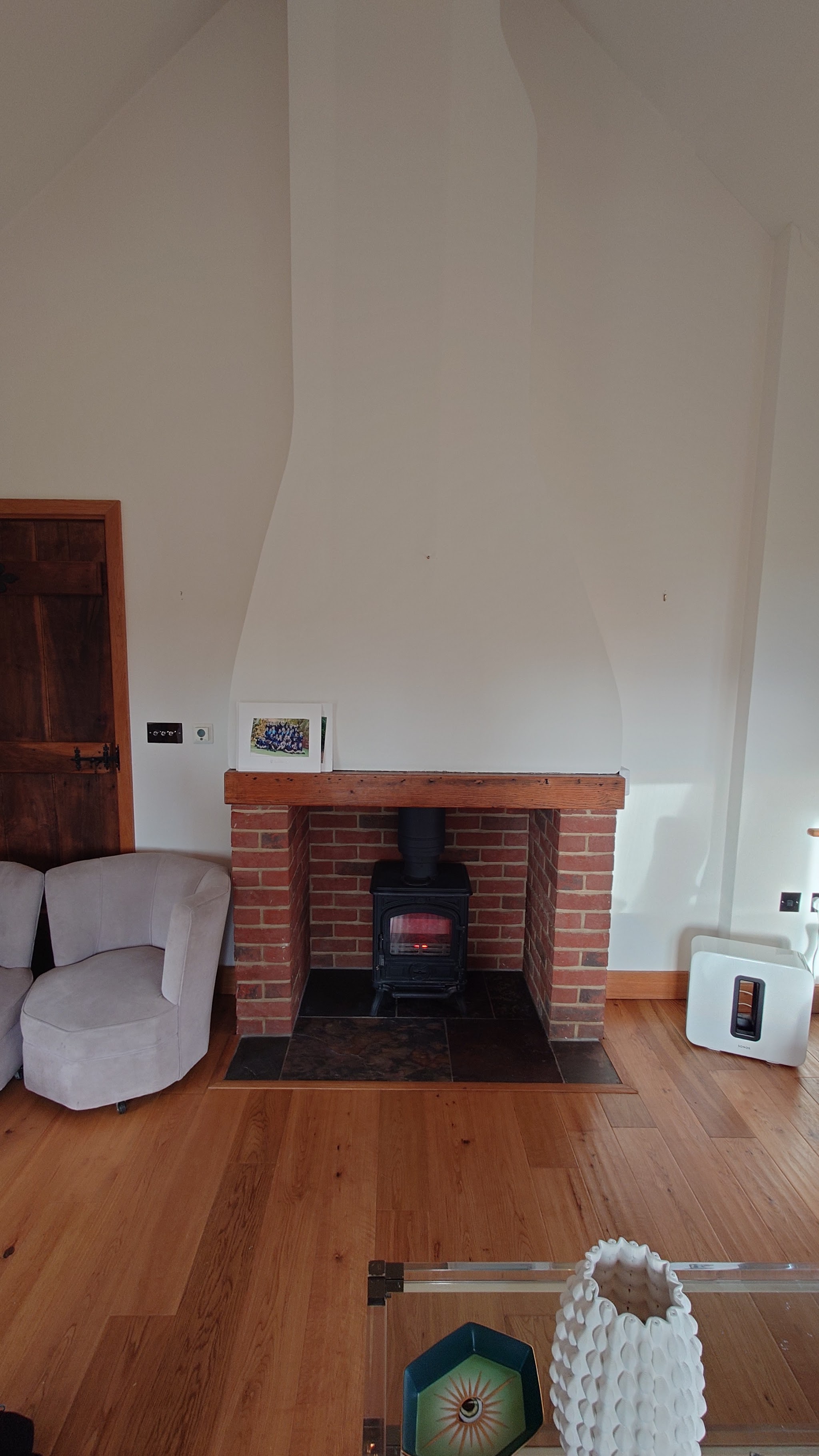 Red-brick fireplace surround with a small stove under a white chimney breast
